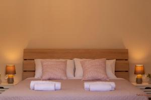 een slaapkamer met een groot bed met twee kussens bij Tabak home Sea side apartment in Chania