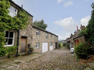 a cobblestone street in a village with stone houses at Darrowby Barn in Skipton