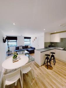 una cucina e un soggiorno con tavolo e sedie bianchi di Prosper House Apartment 6 a Norwich
