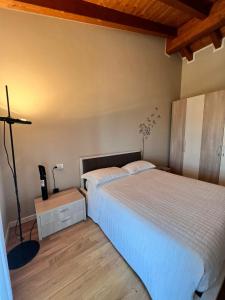 a bedroom with two beds and a lamp in it at Appartamento Corina in Sirmione