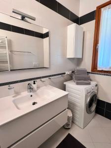 a bathroom with a sink and a washing machine at Appartamento Corina in Sirmione