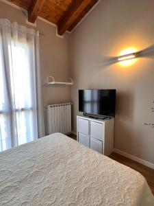 a bedroom with a bed and a flat screen tv at Appartamento Corina in Sirmione
