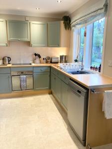 a kitchen with green cabinets and a sink at Cedar Lodge in Oban