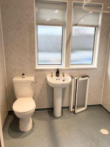 a bathroom with a toilet and a sink at Cedar Lodge in Oban