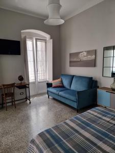 a living room with a blue couch and a table at B&B Novecento Italiano in Altamura