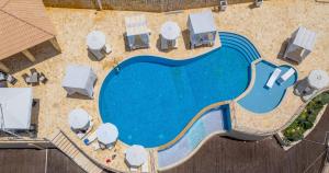 an overhead view of a swimming pool with tables and chairs at Petani Bay Hotel - Adults Only in Vovikes