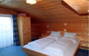 Bett in einem Zimmer mit einer Holzwand in der Unterkunft Gästehaus Conny in Prägraten