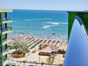 a beach with a bunch of people in the ocean at SUNSHINE PLACE ApartHotel & Spa Mamaia Nord in Mamaia Sat/Năvodari