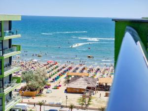 una playa con un montón de gente en el océano en SUNSHINE PLACE ApartHotel Pool & Spa Mamaia Nord en Mamaia Nord – Năvodari