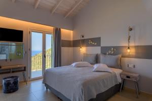 a bedroom with a bed with a view of the ocean at Petani Bay Hotel - Adults Only in Vóvikes