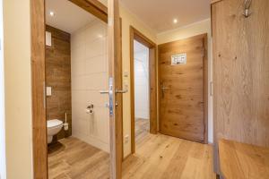 a bathroom with a toilet and a wooden door at Hotel Die Metzgerstubn in Sankt Michael im Lungau