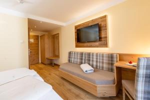 a hotel room with a bed and a tv at Hotel Die Metzgerstubn in Sankt Michael im Lungau