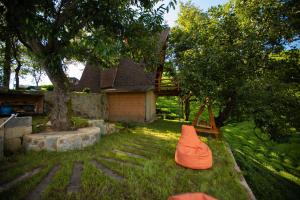 uma almofada laranja sentada na relva ao lado de uma casa em Oruba bungalov em Rize