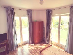 a living room with large windows and a red cabinet at Green house in Čavle