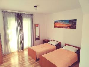 um quarto de hotel com duas camas e uma janela em Green house em Čavle