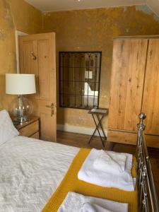 een slaapkamer met een bed, een lamp en een raam bij Shoreline in St Ives