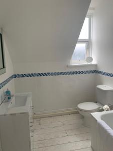 een witte badkamer met een toilet en een wastafel bij Shoreline in St Ives