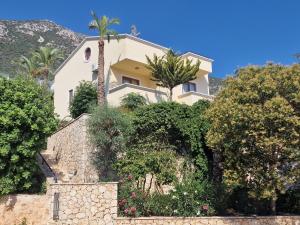 a house on a hill with trees and bushes at Villa Gwendoline in Kalkan