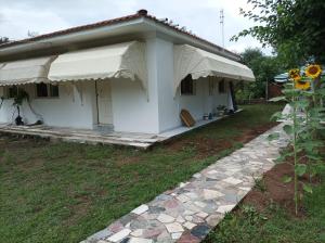 a small white house with a porch and a sunflower at thassossweethome in Limenas