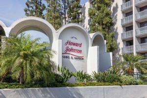 ein Schild für ein Hotel vor einem Gebäude in der Unterkunft Howard Johnson by Wyndham Anaheim Hotel & Water Playground in Anaheim