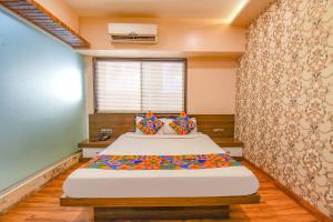 um quarto com uma cama grande num quarto em FabExpress Glory em Chinchwad