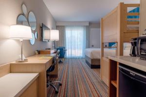 a hotel room with a bed and a desk at Howard Johnson by Wyndham Anaheim Hotel & Water Playground in Anaheim