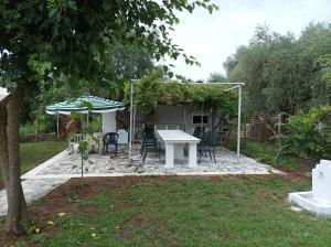 a patio with a table and chairs and an umbrella at thassossweethome in Limenas
