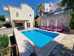 a villa with a swimming pool in front of a house at Villa Gwendoline in Kalkan