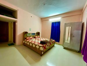 a bedroom with a bed and a blue window at MOUNTAIN HOME STAY -RANG, at Reckong Peo - Kalpa, Near Goyal Motors, Way to Petrol Pump at ITBP Quarters in Kalpa