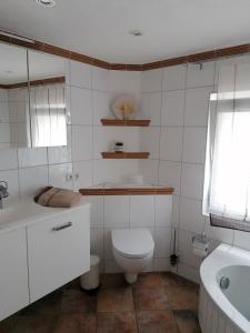 a bathroom with a toilet and a sink and a tub at Casa Mediteran NEU in Reichensachsen