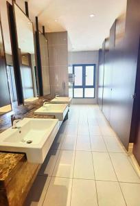 a bathroom with three sinks and two mirrors at Almas Forever Love 100mbps Netflix!! by STAY in Nusajaya