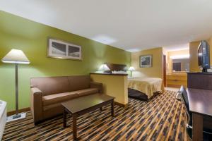 a hotel room with a couch and a bed at Quality Inn & Suites Mt Dora North in Mount Dora