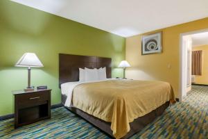 a hotel room with a bed and a night stand with two lamps at Quality Inn & Suites Mt Dora North in Mount Dora