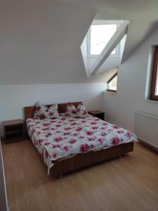 a bedroom with a bed with a floral bedspread at Casa Drumețului in Făgăraş