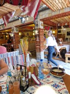 a woman walking past a table in a restaurant at Apartment Slanic moldova in Slănic-Moldova