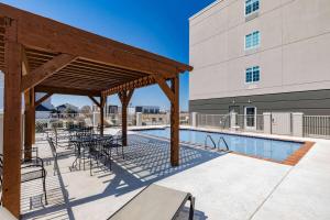 a patio with tables and chairs next to a pool at Hawthorn Extended Stay by Wyndham Ardmore in Ardmore