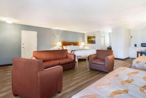 een hotelkamer met een bed en een bank en stoelen bij Quality Inn - On The Lake Clarksville-Boydton in Clarksville