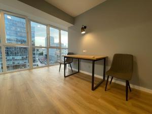 una scrivania e una sedia in una stanza con finestre di Partner Guest House a Kiev