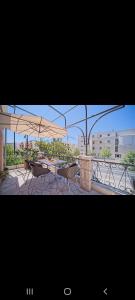 un patio con 2 sillas y una mesa con sombrilla en Apartman Monaco, en Makarska