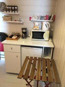 eine kleine Küche mit einer Theke mit einer Mikrowelle und einer Bank in der Unterkunft Un coin de forêt in Courmas