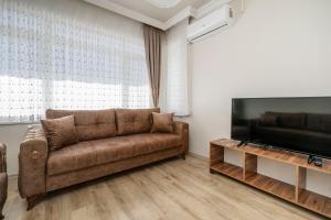 a living room with a couch and a flat screen tv at Spacious apartment in the historical center of Bursa in Bursa