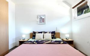 a bedroom with a bed with a pink blanket at Apartman Petra in Plitvička Jezera
