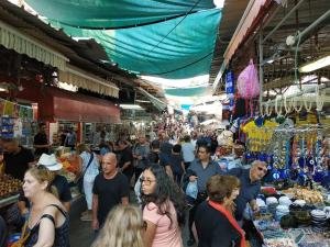 una multitud de personas caminando por un mercado en Private rooms near the beach center en Tel Aviv
