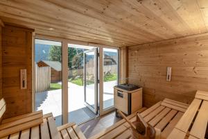 una sauna con paredes y ventanas de madera y una estufa en Hotel Die Metzgerstubn en Sankt Michael im Lungau