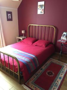 ein Schlafzimmer mit einem großen Bett mit roter Bettwäsche in der Unterkunft Un coin de forêt in Courmas