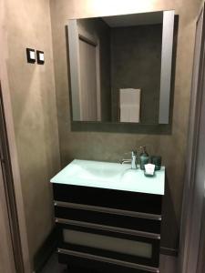 La salle de bains est pourvue d'un lavabo blanc et d'un miroir. dans l'établissement Casa da Roda - Turismo de Habitação, à Pinhel