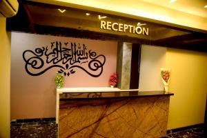 a lobby with a reception sign on the wall at Charyana Backpackers in Ahmedabad