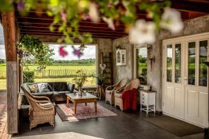 eine Terrasse mit Stühlen, einem Sofa und einem Tisch in der Unterkunft Gasthoeve-De-Drie-Eiken in Oploo