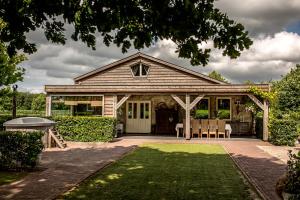 a house with a porch with a table and chairs at Gasthoeve-De-Drie-Eiken in Oploo