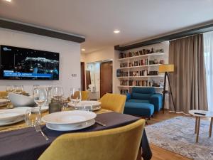 ein Esszimmer mit einem Tisch mit Stühlen und einem TV in der Unterkunft Kiara Apartments in Sweti Konstantin